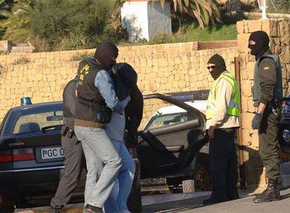 Uno de los ladrones islamistas es conducido a un chalé de Estepona (Málaga) para hacer un registro.