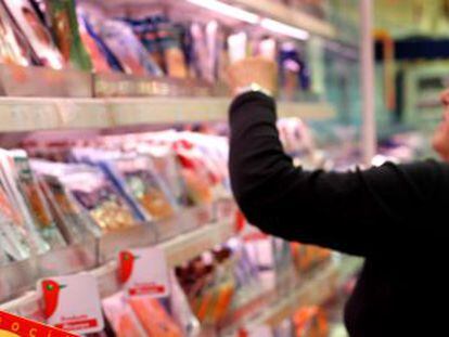 Una mujer selecciona productos en un supermercado.