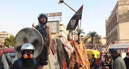 Ahmed Nuri Hasan, en el centro y con una parabólica de escudo, durante las protestas en Bagdad.