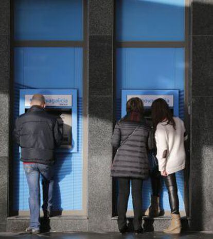 Personas sacan dinero de una sucursal bancaria.