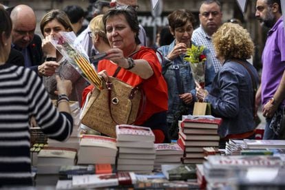 Una mujer adquiere un libro en una parada en La Rambla de Barcelona durante la festividad de Sant Jordi de 2019.