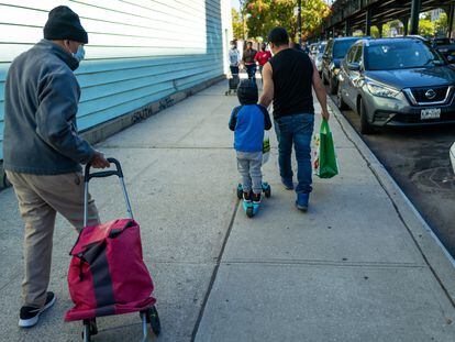 Una familia con una bolsa con alimentos donados en Nueva York.