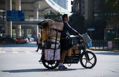 A pesar de todo el dinero que se mueve este día, Alibaba solamente se queda con un pequeño porcentaje de comisión por anunciar los productos en sus portales. También ingresa por publicidad. En la imagen, un repartidor en una motocicleta cruza una calle durante su jornada laboral, en el Día del Soltero, en Shangai.
