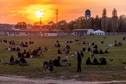 Un grupo de personas disfruta de la puesta de sol en el parque del antiguo aeropuerto de Tempelhof, en Berlín, el miércoles 28 de abril.