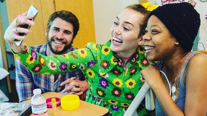Liam Hemsworth y Miley Cyrus con una paciente del hospital de San Diego.