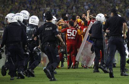La policía escolta a los jugadores del Galatasaray, que celebran el título de Liga.