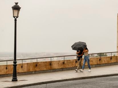 Una pareja se protege de la lluvia, el jueves en Toledo.