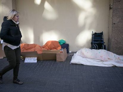 Una dona passa per davant de dos sensesostre a Barcelona.