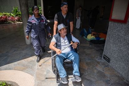 Juan Pablo Chacón es trasladado en silla de ruedas por un médico de PDVSA para inyectarle suero.