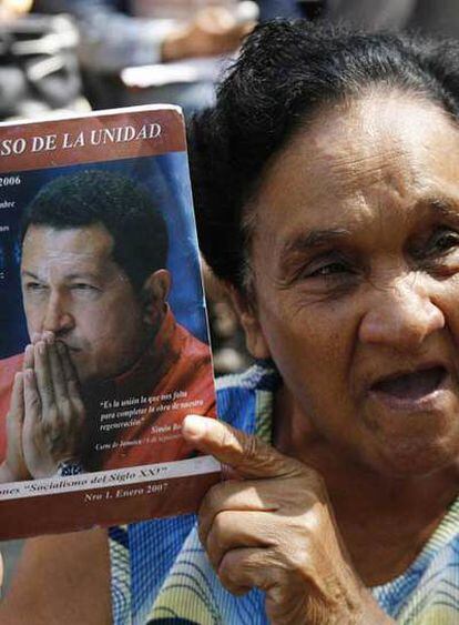 Un mujer muestra un libro sobre Hugo Chávez en la sesión parlamentaria de ayer, en Caracas.