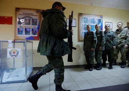 Un militar de la autoproclamada República Popular de Lugansk camina con un rifle después de votar en la consulta para unirse a Rusia, este viernes.