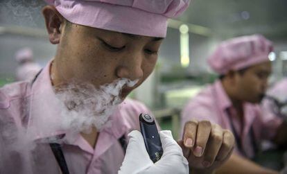 Una trabajadora de la compañía de cigarrillos electrónicos china Kanger Tech prueba el producto en Shenzhen (China).