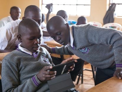 Un grupo de estudiantes interactúan con un tutor de IA en un aula en Nairobi, Kenia.