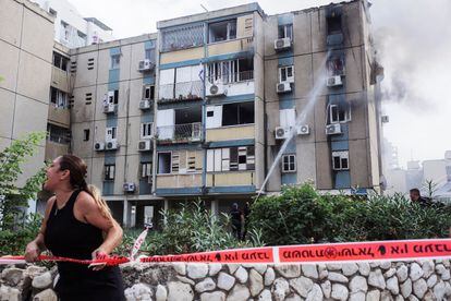 Una mujer grita mientras se sofoca el incendio en un edificio dañado en Tel Aviv, por un cohete lanzado desde la franja de Gaza, este viernes.