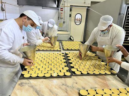 Pastry chefs fill the cream cakes in the Nortejo bakery, in Lisbon.