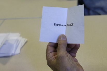 Un voluntario, mientras el recuento de votos, con una papeleta de Emmanuel Macron en La Penne sur Huveaune, cerca de Marsella, sur de Francia.