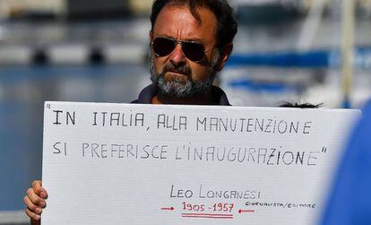 Un hombre sujeta un cartel de protesta en el día de los funerales de las víctimas de Génova.