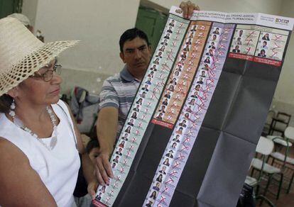 Una mujer muestra los votos nulos mayoritarios en una mesa electoral en Santa Cruz (Bolivia).