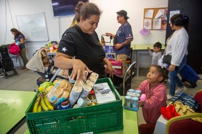Una niña acompaña este miércoles a su madre en la recogida de comida en el local de la ONG Esperanza Latina de San Sebastián.