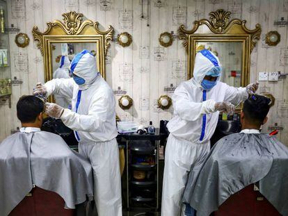 Barberos protegidos contra el coronavirus en Dhaka.
