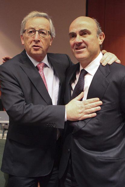 El presidente del Eurogrupo, Jean-Claude Juncker, saluda a Luis de Guindos (derecha).