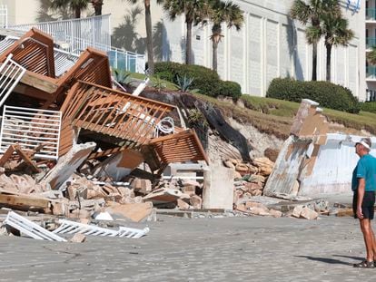 Una pareja comprueba los daños causados por el huracán 'Ian' en la playa de Daytona, este lunes.