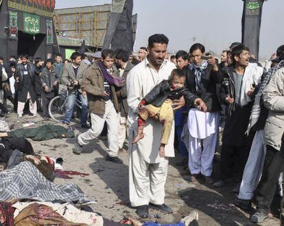 Un hombre lleva a un niño en brazos tras el atentado contra los chiíes en Kabul.