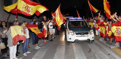 Un grup de persones acomiaden a agents de la Guàrdia Civil que viatgen cap a Catalunya.