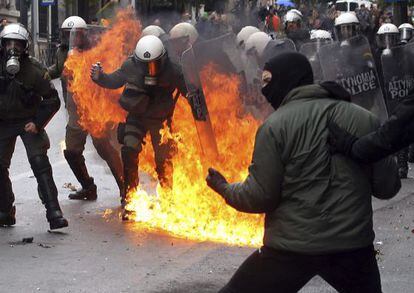 Manifestantes se enfrentan con polic&iacute;as antidisturbios durante una protesta con motivo de la huelga general en Atenas