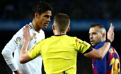 Varane y Alba esuchan al árbitro durante el clásico.