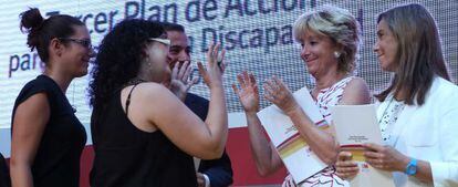 Aguirre saluda a una mujer discapacitada durante la presentaci&oacute;n del plan.