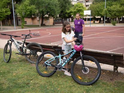 Elena López aparca su bici ante la mirada de su padre Javier López.