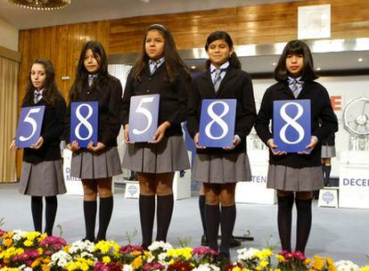 Las niñas del Colegio de San Ildefonso muestran el número 58. 588 correspondiente al primer premio del sorteo extraordinario de 'El Niño'.