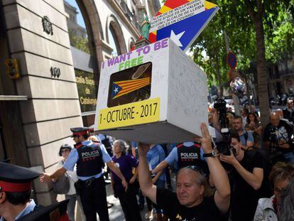 Un hombre sostiene una urna de cartón con una estelada frente al Tribunal Superior de Justicia de Barcelona.