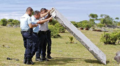 Policías franceses inspeccionan en 2015 en La Reunión una pieza del MH370. .