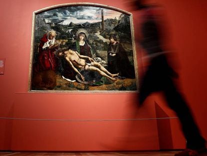 Una mujer pasa ante la obra 'Piedad desplá', de Bartolomé Bermejo en el muestra que el Museo del Prado le dedica al artista.
