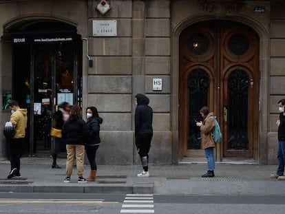 Decenas de personas hacen cola este miércoles para someterse a pruebas de antígenos o PCR para la detección de la covid-19 en un laboratorio de Barcelona, este miércoles.