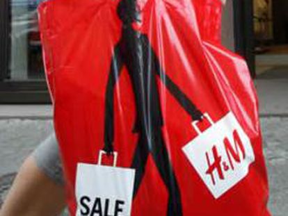 Una persona con una bolsa de Hennes and Mauritz (H&M)