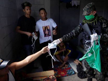 Militares hondureños reparten mascarillas a los prisioneros de la cárcel de Tamara.