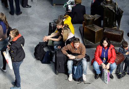 Un grupo de viajeros esperan en uno de los andenes de la estación de Atocha durante la jornada de huelga en Renfe.