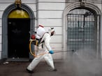 A cleaning worker wearing personal protective equipment (PPE) disinfects a street in Mexico City, on May 7, 2020, amid the new coronavirus pandemic. (Photo by ALFREDO ESTRELLA / AFP)