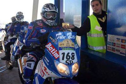 Los motociclistas, pagando el peaje en la autopista Marbella-Algeciras.