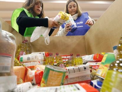 Unas voluntarias recogen comida en un supermercado de Barcelona para un banco de alimentos.