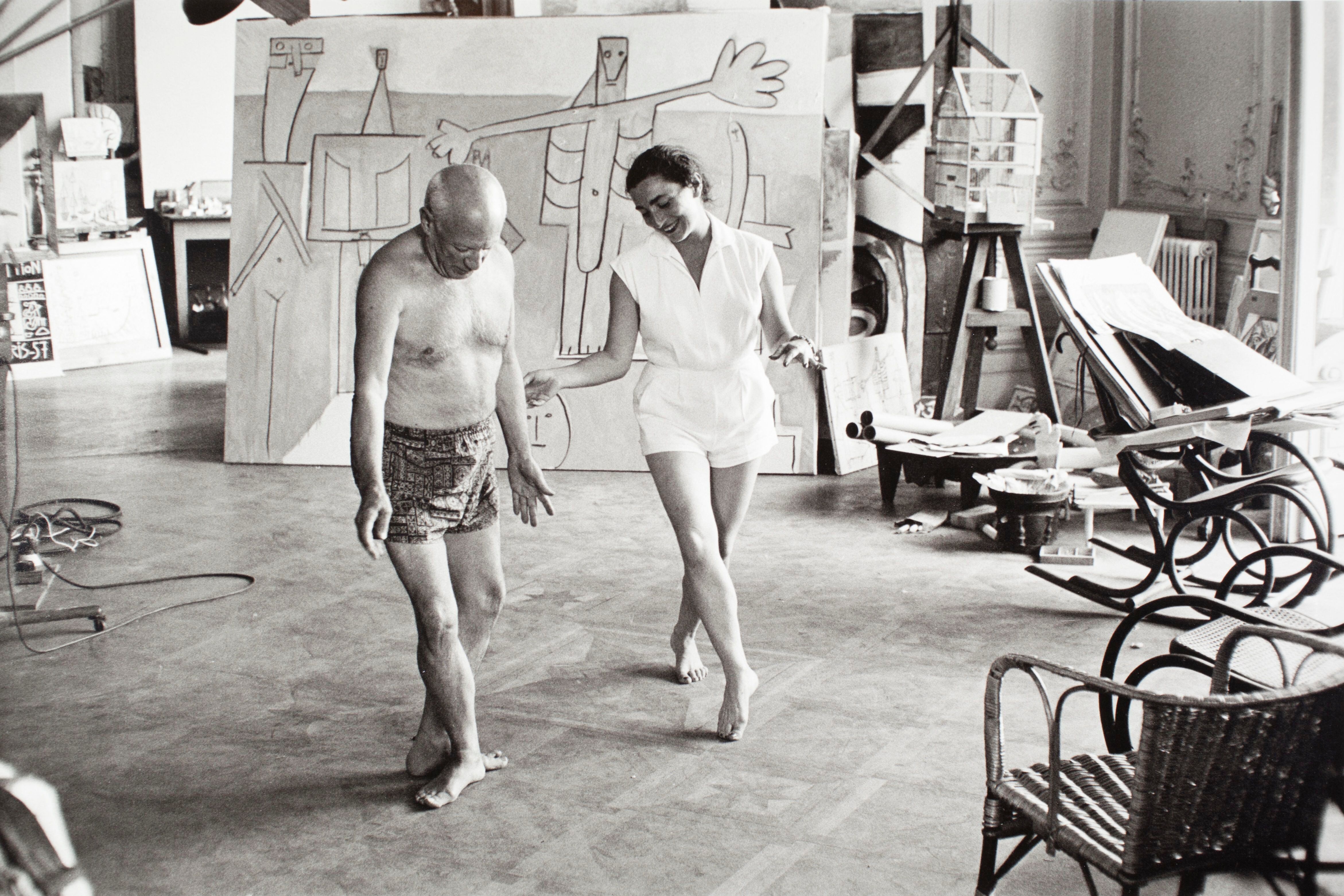 Picasso y su esposa Jacqueline Roque se divierten ensayando unos pasos de ballet delante de la obra 'Bañistas en La Garoupe' en La Californie, la villa del artista en Cannes, en el verano de 1957.