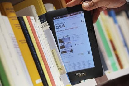 Un visitante saca un libro electrónico de una estantería en la Feria de Fráncfort.