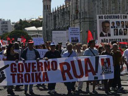 Un grupo de manifestantes sujeta una pancarta en la que se lee &quot;&iexcl;Gobierno de la troika, a la calle!&quot; en Lisboa.  