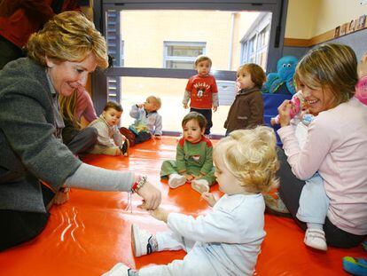 Esperanza Aguirre juega con una niña de la guardería Sol Solito, financiada por la Comunidad de Madrid.