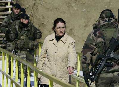 Una mujer cruza el puente que separa  a serbios y albanokosovares en Mitrovica, vigilado por soldados de la Kfor (las fuerzas de la OTAN).