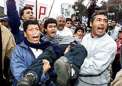 Manifestantes portan el cuerpo de un herido en una manifestación contra el Gobierno de Alejandro Toledo en Lima.