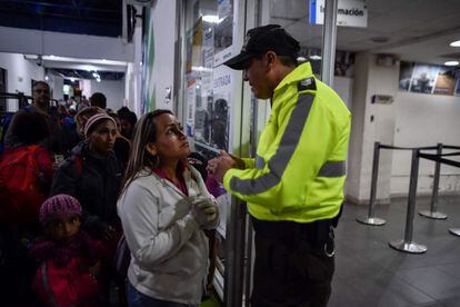 Un oficial de policía ecuatoriano explica el procedimiento de entrada al país a migrantes venezolanos en la oficina de migración de Rumichaca en Tulcán (Ecuador). 